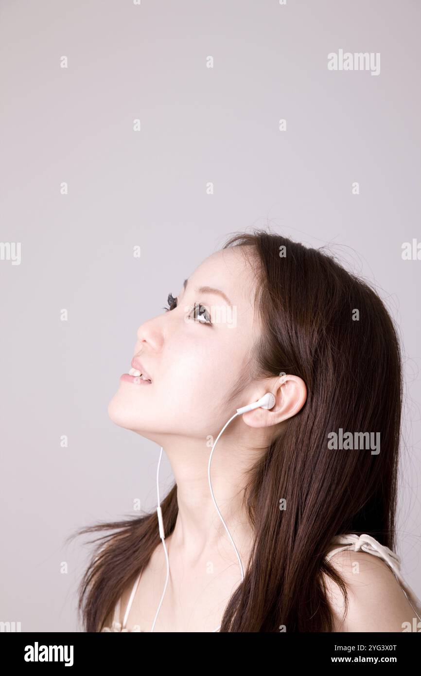 Donna che ascolta musica con le cuffie Foto Stock