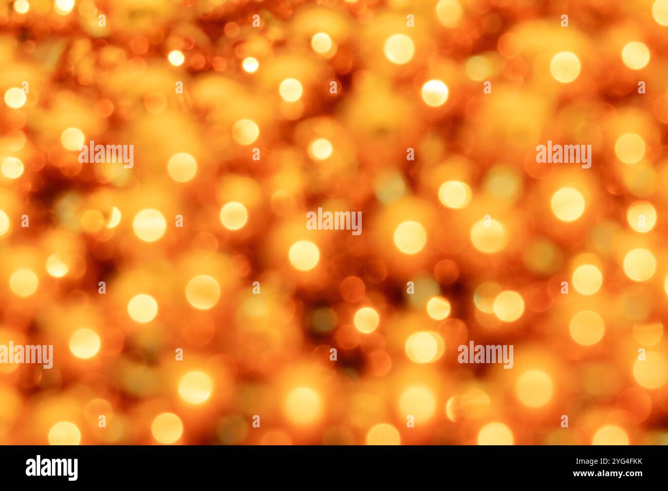Uno sfondo caldo e vibrante caratterizzato da luci bokeh gialle dorate con cerchi morbidi e luminosi. L'effetto sfocato crea un'atmosfera accogliente e radiosa, ma Foto Stock