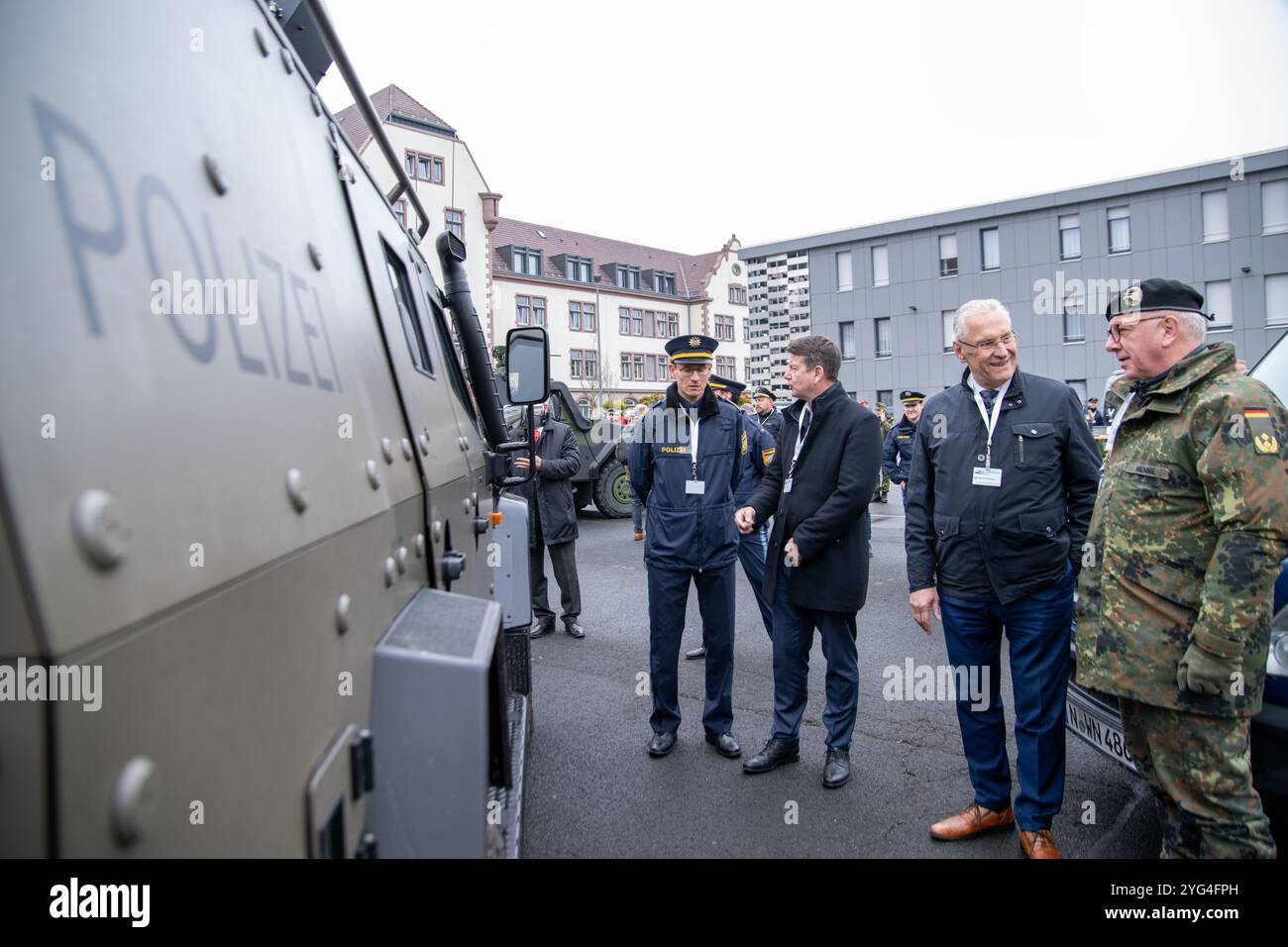 06 novembre 2024, Baviera, Würzburg: Il ministro degli interni bavarese Joachim Herrmann (CSU, 2° da destra) guarda un veicolo speciale della polizia con armature e armi sul tetto. Durante una mostra nell'ambito dell'esercitazione antiterrorismo "MainTex 2024", la polizia, le forze armate tedesche, i vigili del fuoco, la BRK e altri servizi di emergenza dimostrano le loro abilità e attrezzature. Gli scenari di esercizio, che sono stati messi in atto dal 4 novembre, comprendono minacce fittizie da sostanze chimiche, biologiche, radiologiche e nucleari. Foto: Pia Bayer/dpa Foto Stock