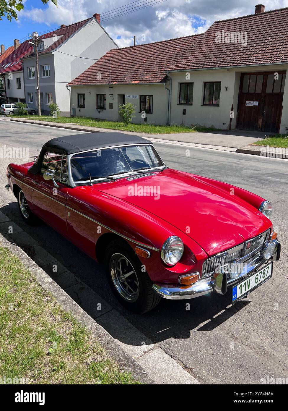 Lysice, Repubblica Ceca - 28 maggio 2022: Una classica MG B Roadster rossa convertibile (1965) parcheggiata in una tranquilla strada suburbana sotto un cielo soleggiato. Il cha Foto Stock