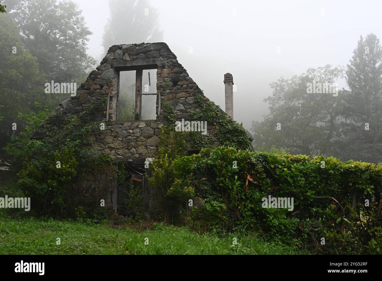 Casa rovinata e abbandonata dopo la distruzione da fuoco in Mysteriou Misty Landscape Foto Stock