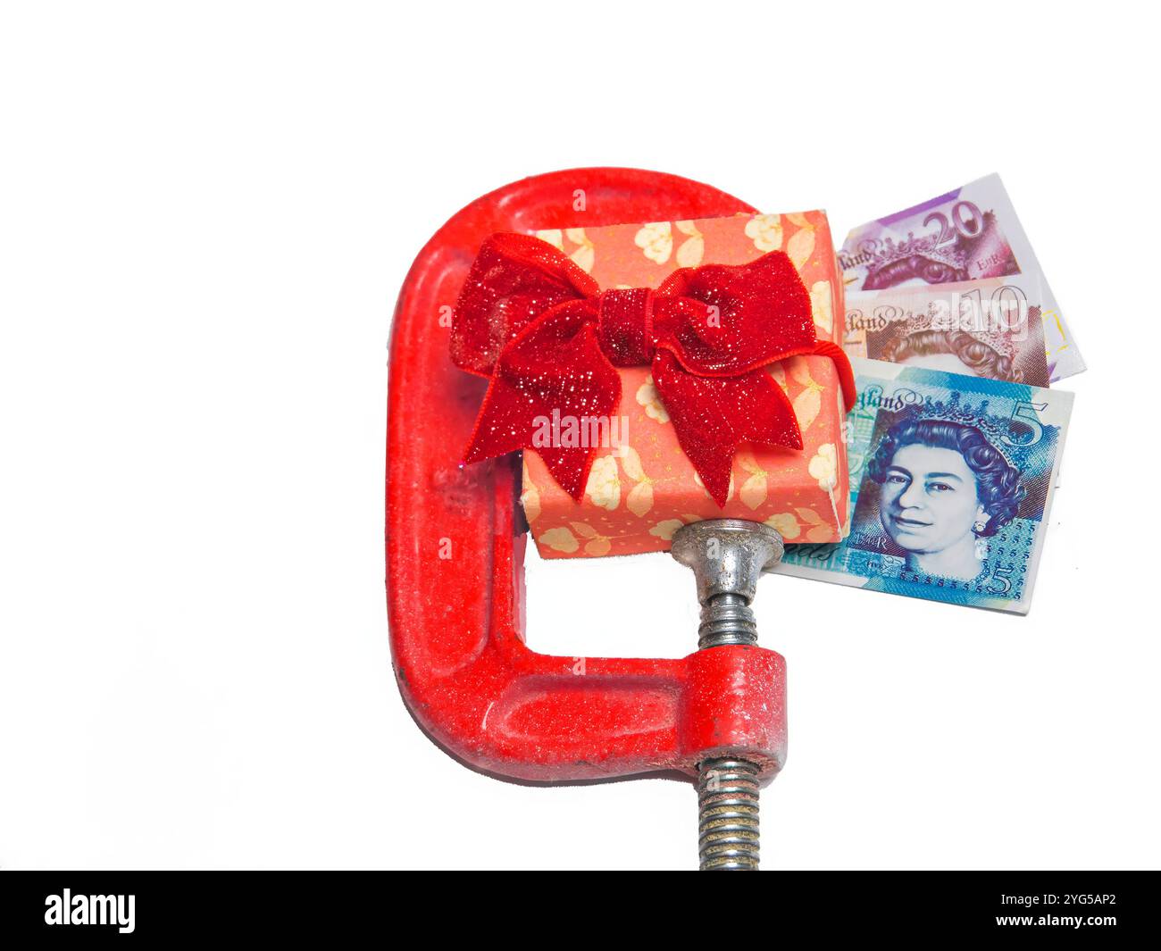 Confezione regalo decorata in carta avvolta rossa e fiocco in morsetto con etichetta e denaro Foto Stock