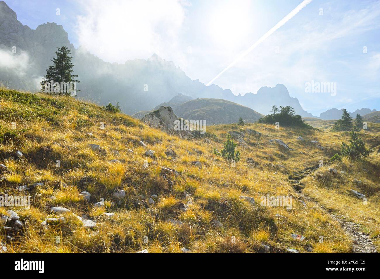Vacanze attive in Montenegro: Paesaggio autunnale dalla valle di Medjukomlje, Parco naturale di Komovi. Vista di una catena montuosa e di una collina con un sentiero sottostante Foto Stock