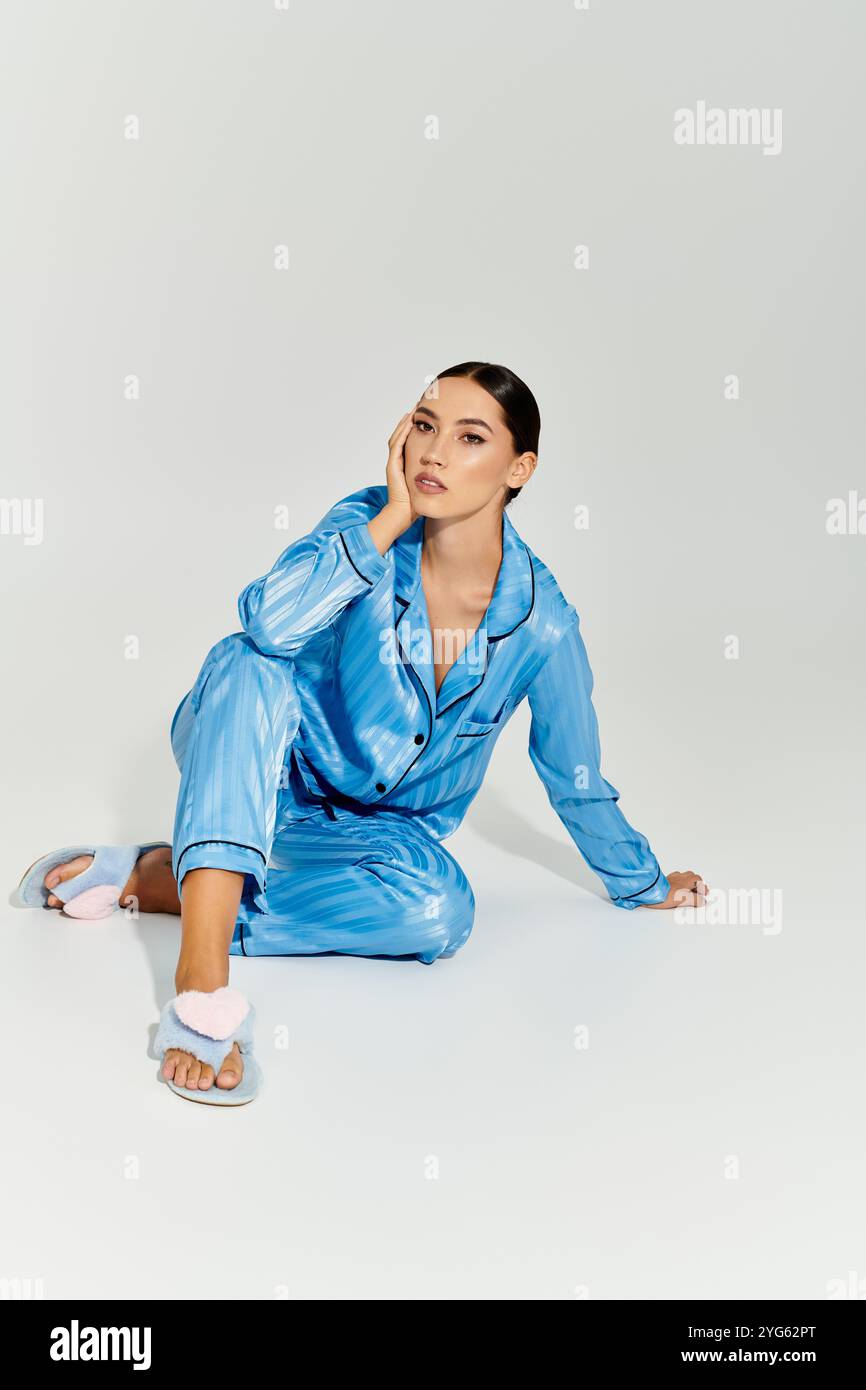 Una giovane donna alla moda siede con cura in un moderno loungewear, trasudando fiducia e stile. Foto Stock
