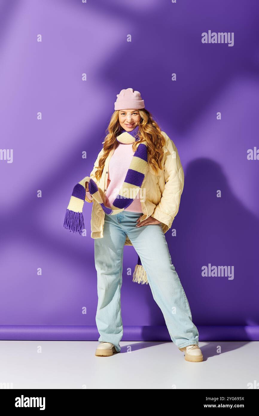 Una giovane donna sicura di sé sfoggia il suo stile in un vivace outfit invernale con accessori divertenti. Foto Stock