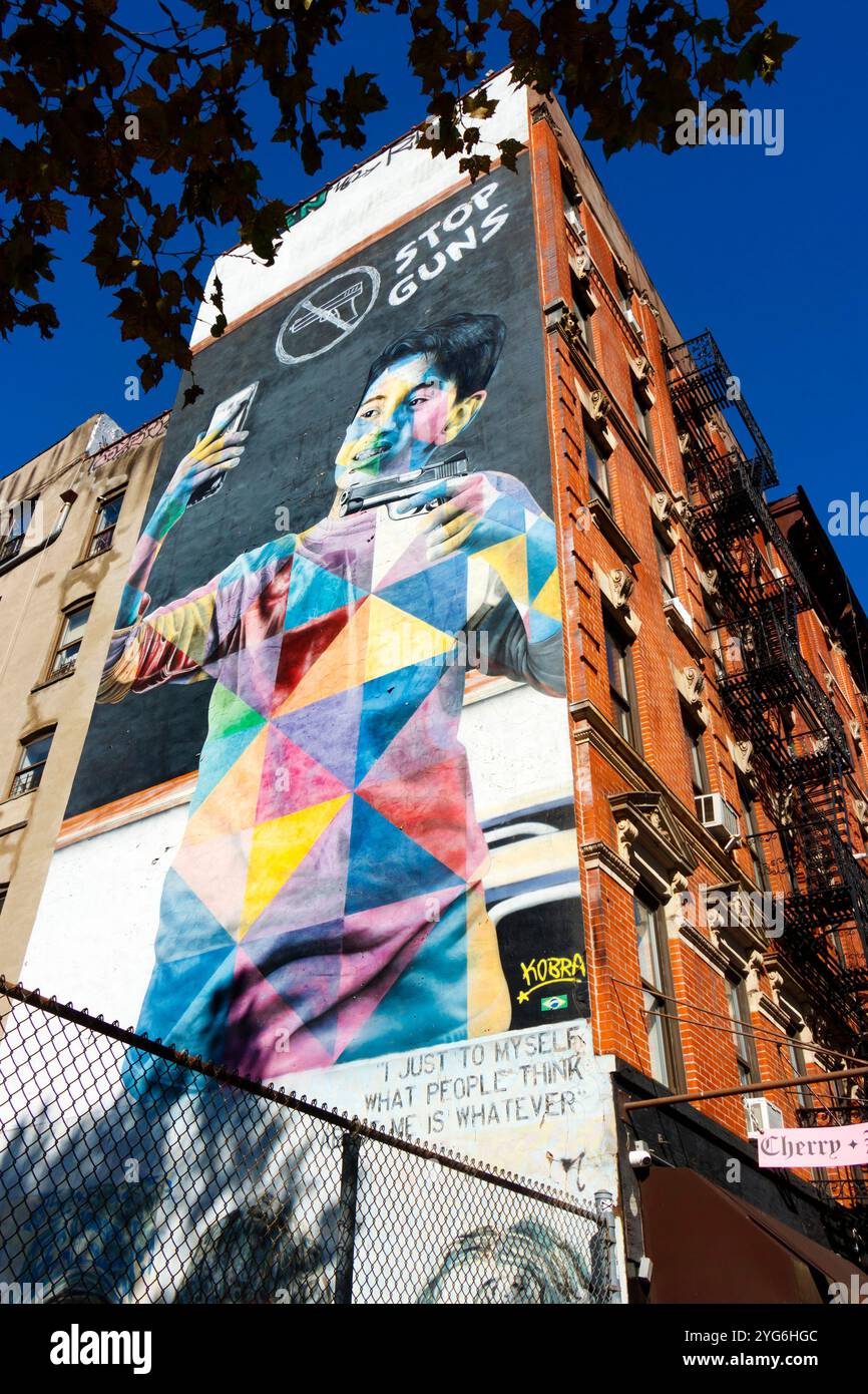 Sosta al murale di Guns Street dell'artista brasiliano Edouard Kobra in Eldridge Street che raffigura un messaggio contro la violenza delle armi sull'edificio di New york Foto Stock