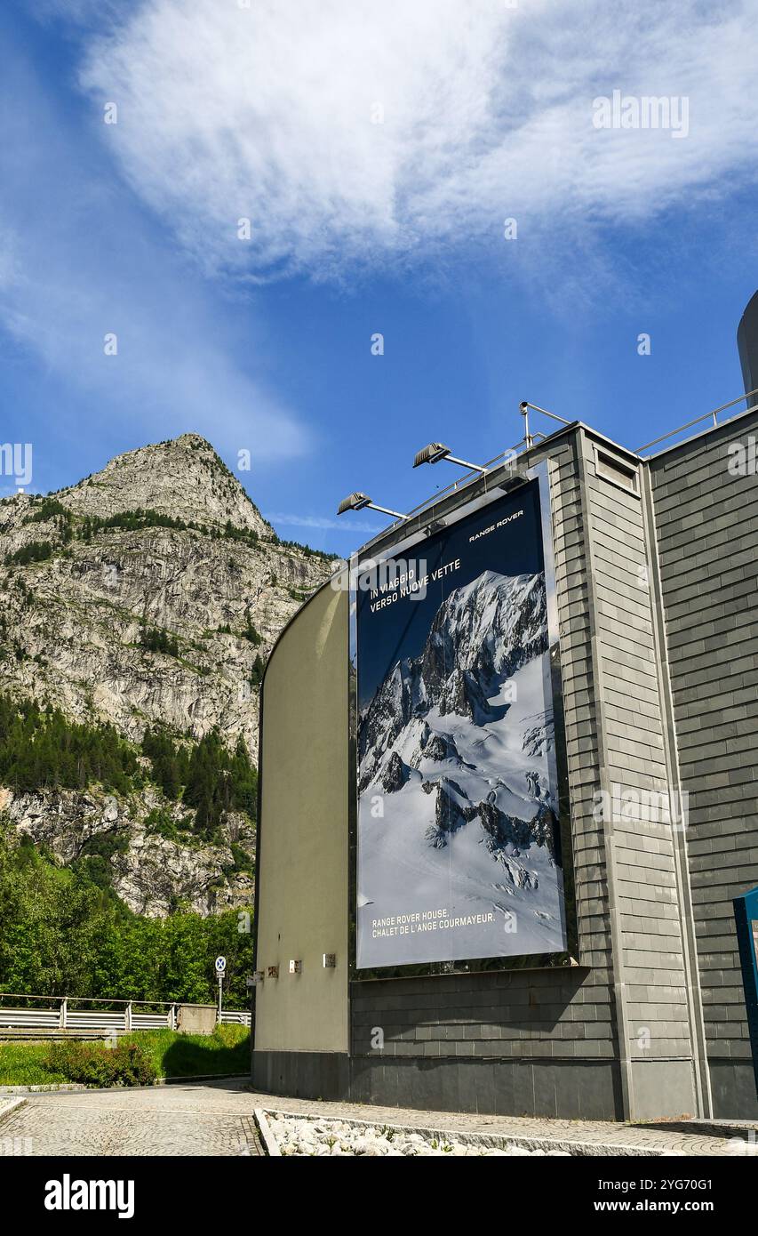 Manifesto danzante sulla facciata del Cinema Palanoir, con la vetta del Monte Chetif sullo sfondo in estate, Courmayeur, Valle d'Aosta, Italia Foto Stock