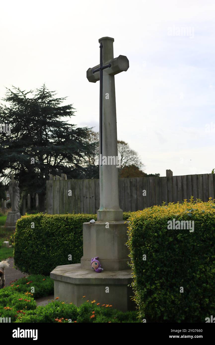Highland Road Cemetery, Southsea, Portsmouth, Hampshire. 17 ottobre 2024. Colore: Una croce alta con una piattaforma a strati sotto di essa, un livello con una pietra commemorativa dipinta a mano e l'altro con un giocattolo per bambini. Foto Stock