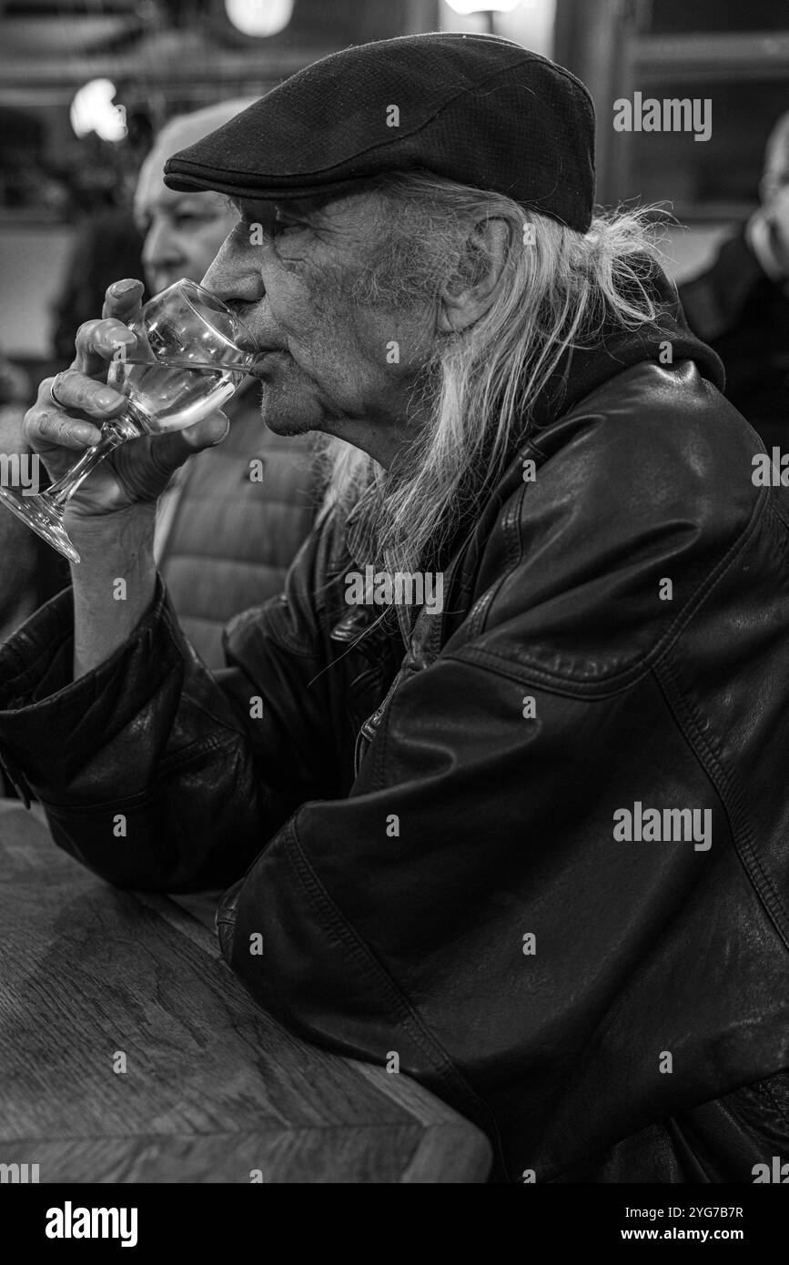 Un uomo anziano beve vino alla French House di Soho, Londra, Regno Unito Foto Stock