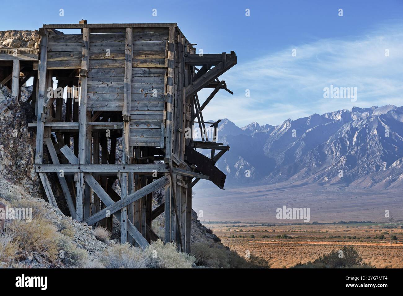 Struttura dello scivolo di caricamento del minerale di legno d'epoca nella Owens Valley a est di Independence, California, con le montagne della Sierra Nevada sullo sfondo Foto Stock