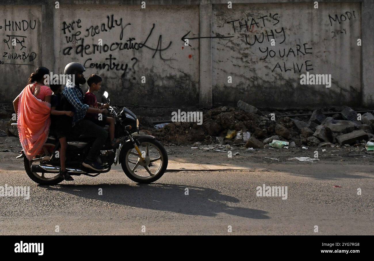 Mumbai, India. 6 novembre 2024. Un uomo corre in moto davanti a graffiti dipinti su un muro nelle strade di Mumbai. I graffiti sono una forma visiva di comunicazione dipinta intorno allo spazio pubblico illegalmente o senza permesso. E' un commento su uno scenario sociale e politico dentro e intorno al paese. (Foto di Ashish Vaishnav/SOPA Images/Sipa USA) credito: SIPA USA/Alamy Live News Foto Stock