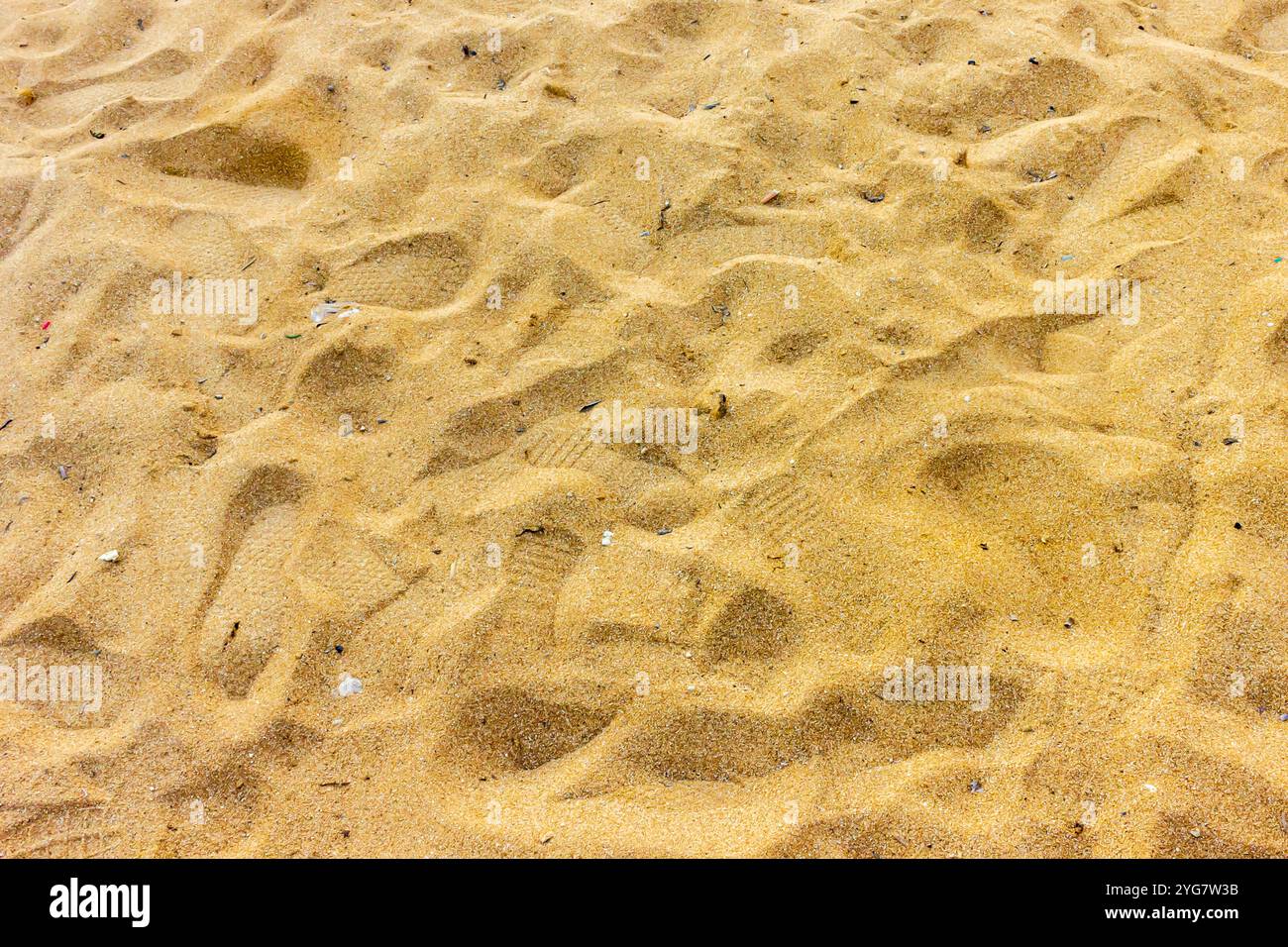 Immagine dettagliata e ravvicinata della sabbia dorata su una spiaggia. I motivi testurizzati creano un ambiente naturale e sereno sulla spiaggia, evocando un senso di tranquillità e. Foto Stock