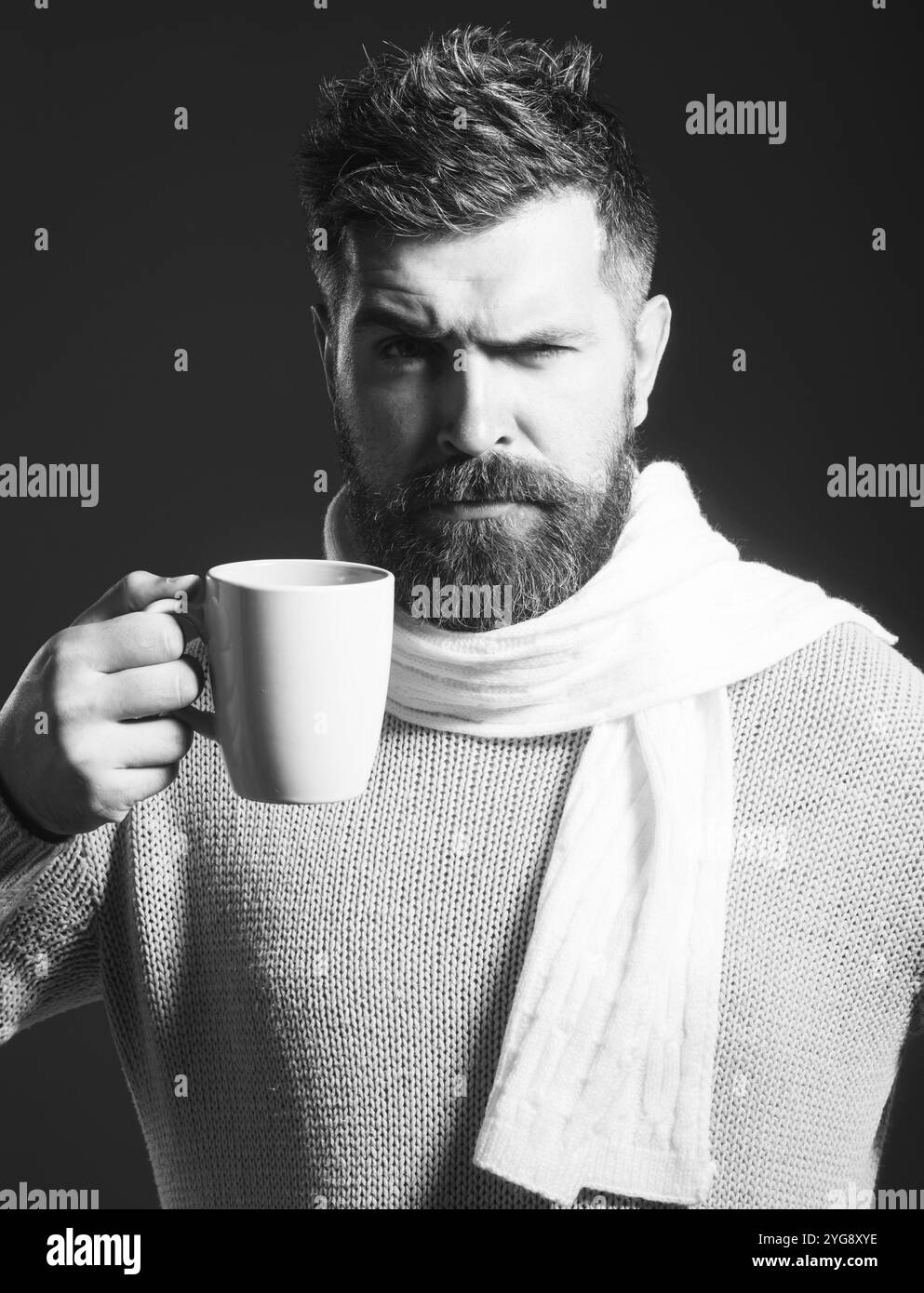 Pausa caffè. Uomo barbuto con tazza di caffè o tè nel caffè. Uomo serio in maglione e sciarpa che beve tazza di caffè o tè. Bel ragazzo in casual noi Foto Stock