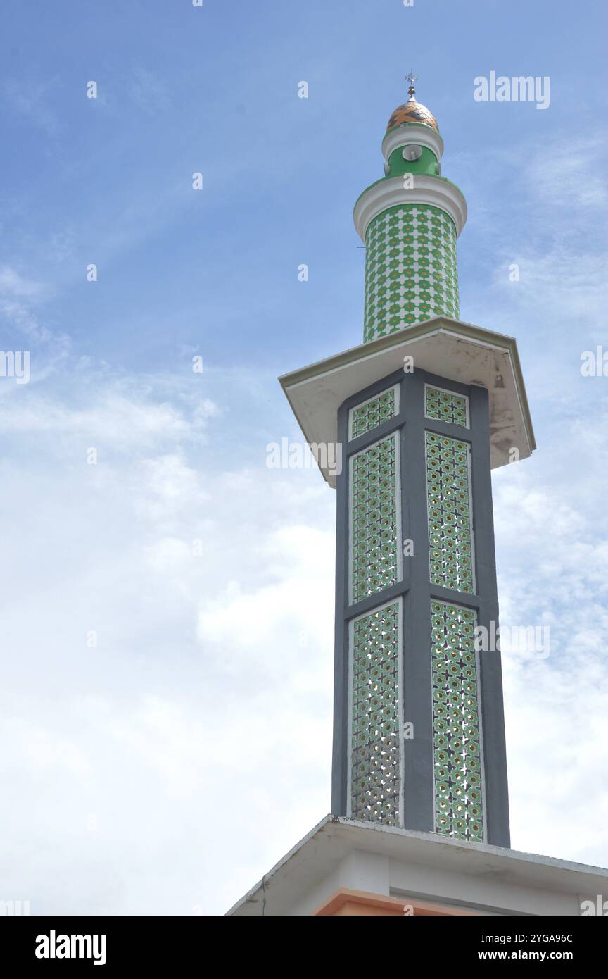 torre della moschea contro il cielo blu e nuvole bianche Foto Stock