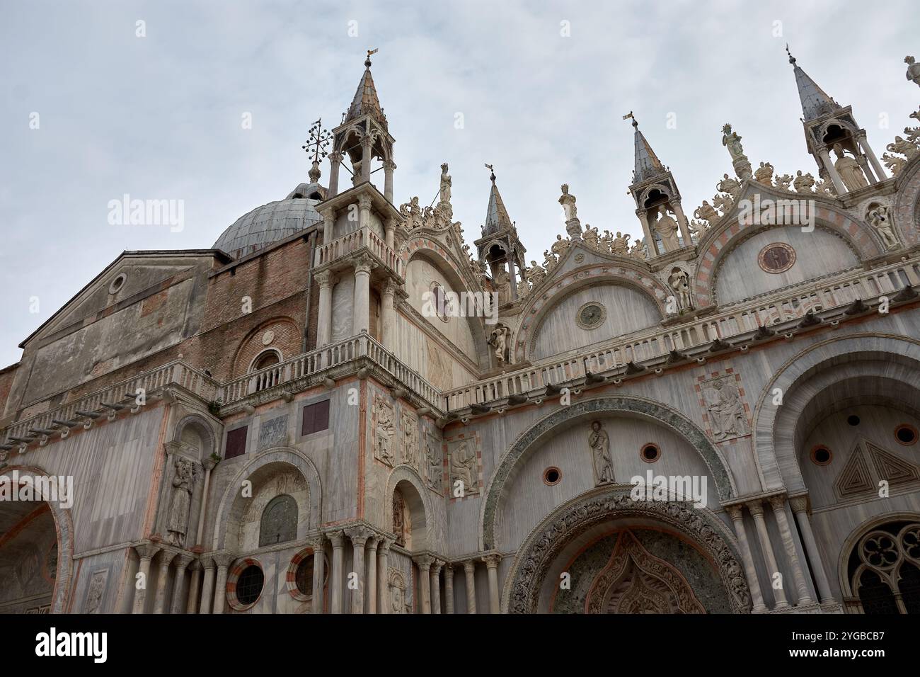 Primo piano della facciata ornata della basilica di San Marco a Venezia. Questo iconico capolavoro bizantino presenta intricati mosaici d'oro, Foto Stock