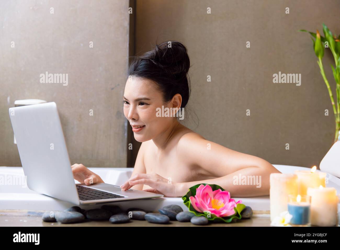 Donne che lavorano con un computer portatile mentre fanno il bagno in Spa, bellezza cura del corpo, vacanza felice, benessere e vita lavorativa equilibrio di vita. Foto Stock