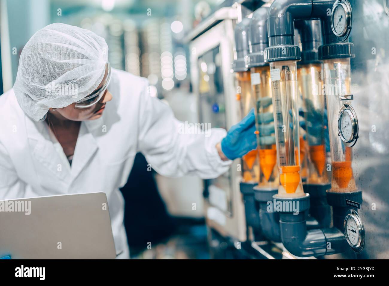 Donne che lavorano all'igiene lavoratrici che lavorano nel controllo di impianti di acqua potabile azionano la macchina per la pressione dell'acqua nella pulizia della fabbrica di bevande. Foto Stock