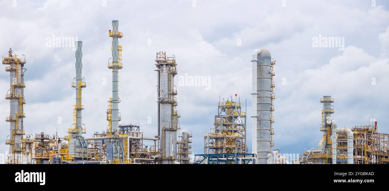 Vista panoramica dell'edificio del complesso industriale della raffineria petrolchimica di petrolio e gas con il suggestivo paesaggio estivo della torre di distillazione Foto Stock