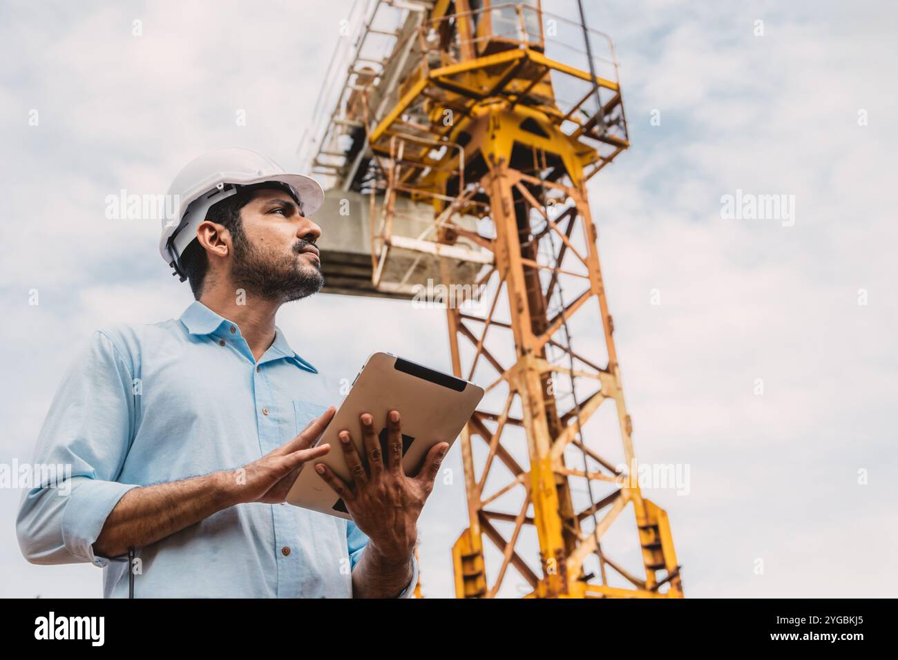 Smart Indian worker Engineer Manager gestisce il cantiere. Caposquadra architetto con gru a torre e tablet computer. Foto Stock