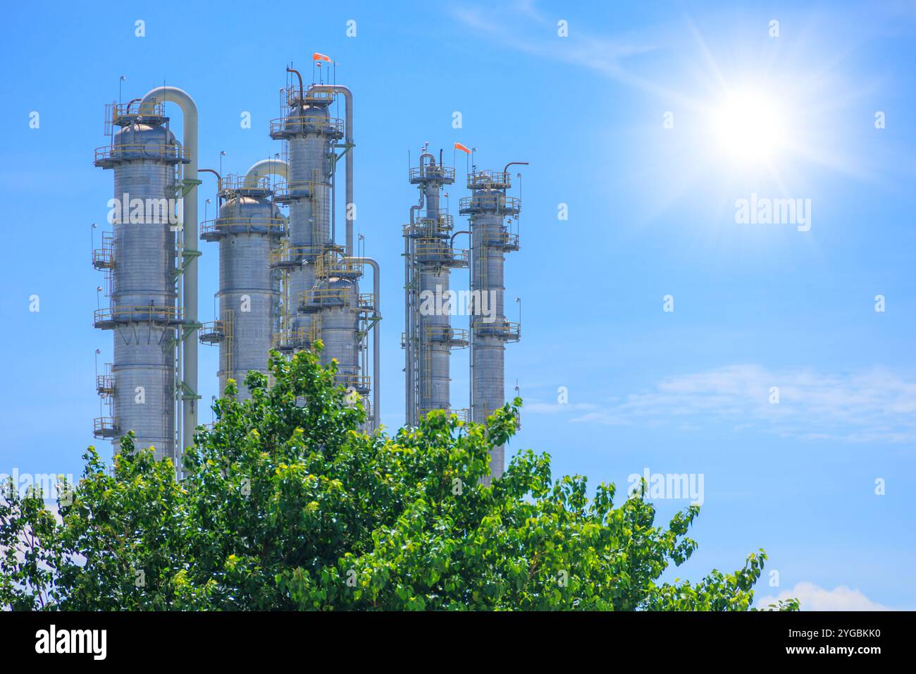 Raffineria petrolchimica verde industriale, petrolifera e di gas con alberi. Produzione ecocompatibile dell'industria per un risparmio sostenibile basso impatto ambientale Foto Stock