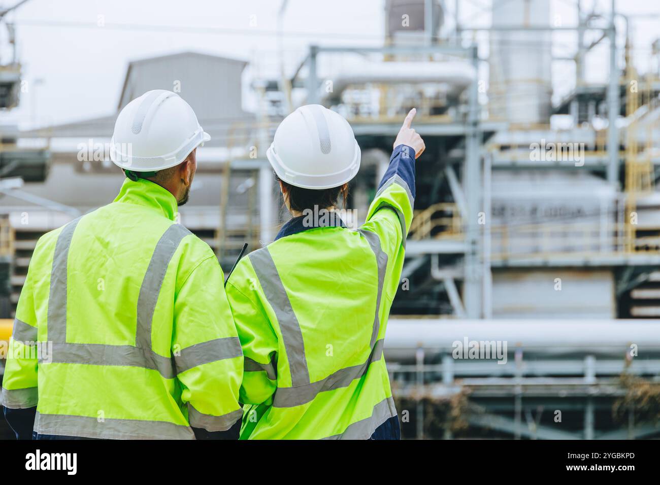 Impianti di ispezione per lavoratori industriali caschi ad alta visibilità discussione sulla sicurezza operativa tubi di servizio, industria Teamwork Refinery Maintenance, Const Foto Stock