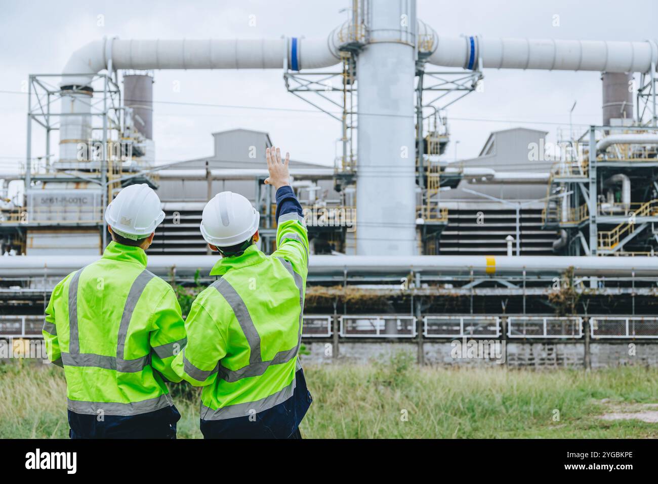 Impianti di ispezione per lavoratori industriali caschi ad alta visibilità discussione sulla sicurezza operativa tubi di servizio, industria Teamwork Refinery Maintenance, Const Foto Stock