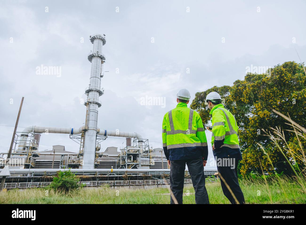 Impianti di ispezione per lavoratori industriali caschi ad alta visibilità discussione sulla sicurezza operativa tubi di servizio, industria Teamwork Refinery Maintenance, Const Foto Stock