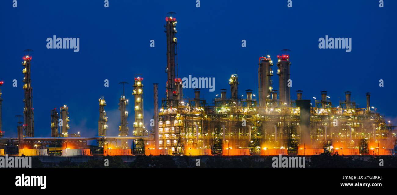 Ampia fotografia panoramica orizzontale della raffineria notturna di petrolio e gas petrolio industria petrolchimica costruzione di impianti cielo notturno azzurro. Foto Stock