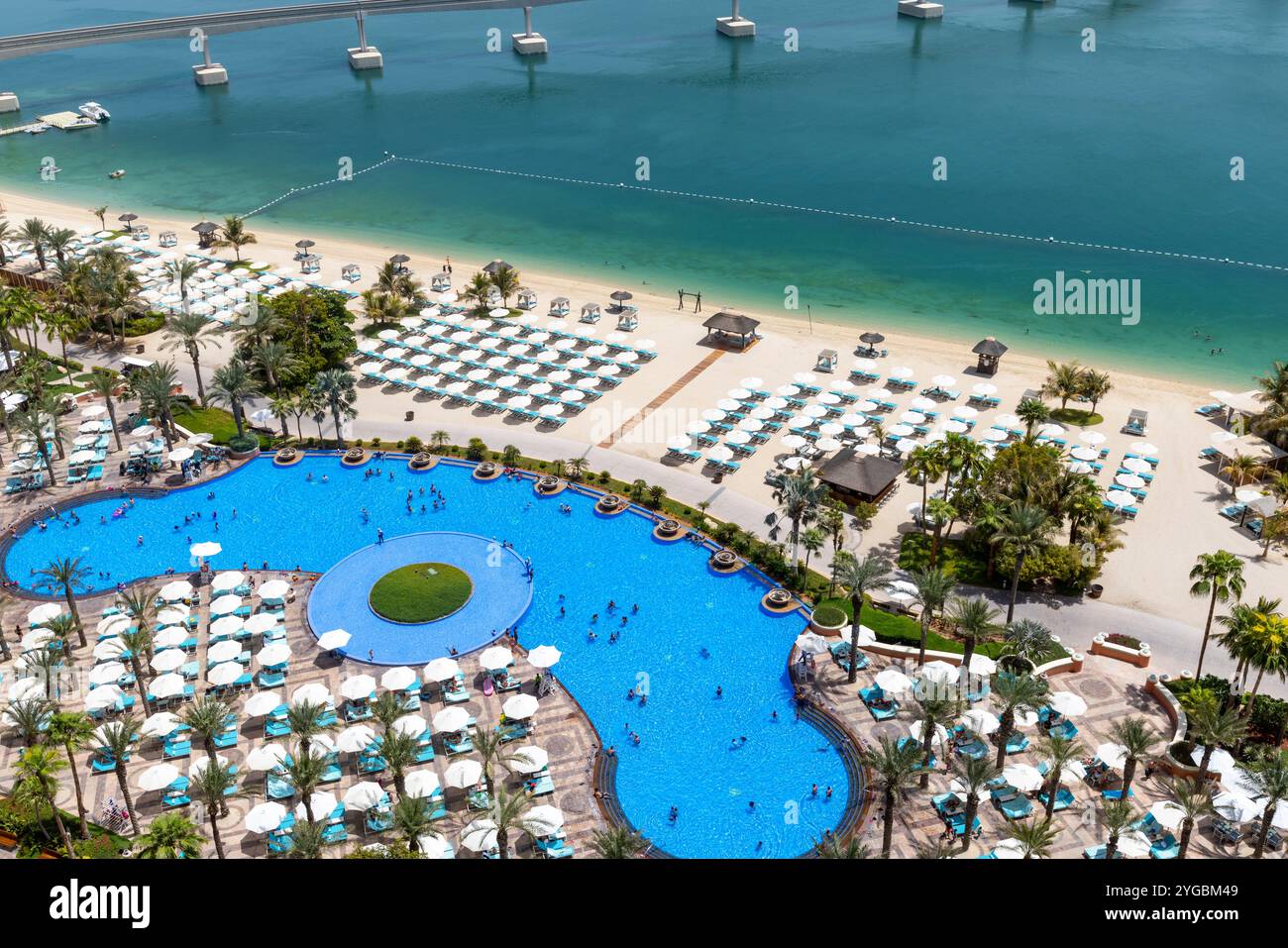 Vista dall'alto della piscina Atlantis The Palm Royal con ombrelloni e lettini intorno alla piscina, Dubai, Emirati Arabi Uniti Foto Stock