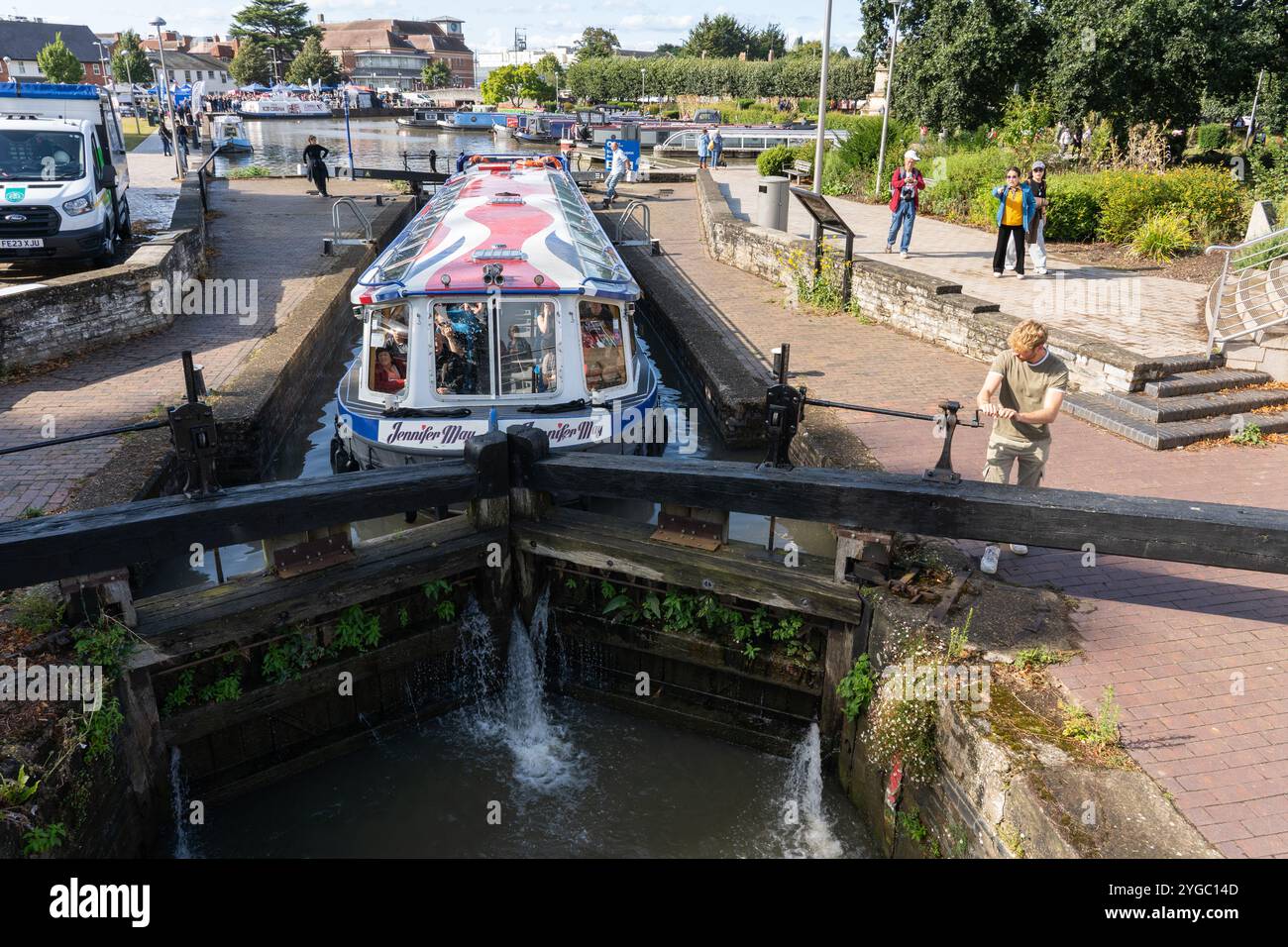 Persona che gira una chiave di chiusura per aprire i cancelli delle chiuse e abbassare il livello dell'acqua per la barca Jennifer May, il canale Stratford, Stratford Upon Avon, Regno Unito Foto Stock