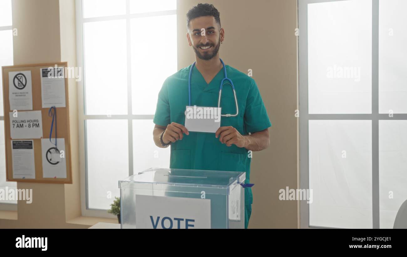 Bel giovane ispanico che vota in una sala interna del college elettorale, tiene un voto e sorride, dimostrando il dovere civico e partecipando attivamente Foto Stock