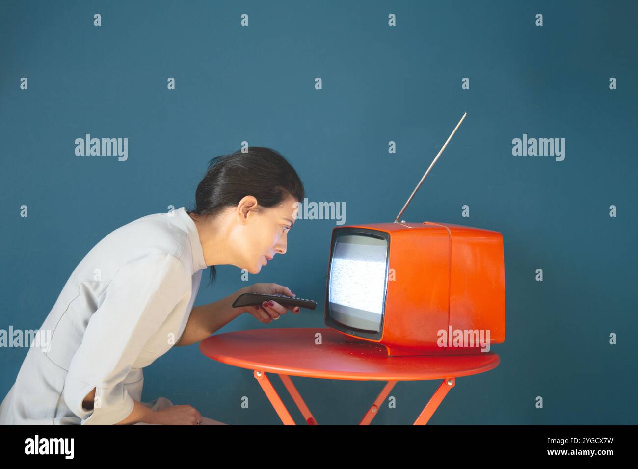 la persona cambia canale su un televisore inclinato, concetto di potere di comunicazione sulle persone Foto Stock