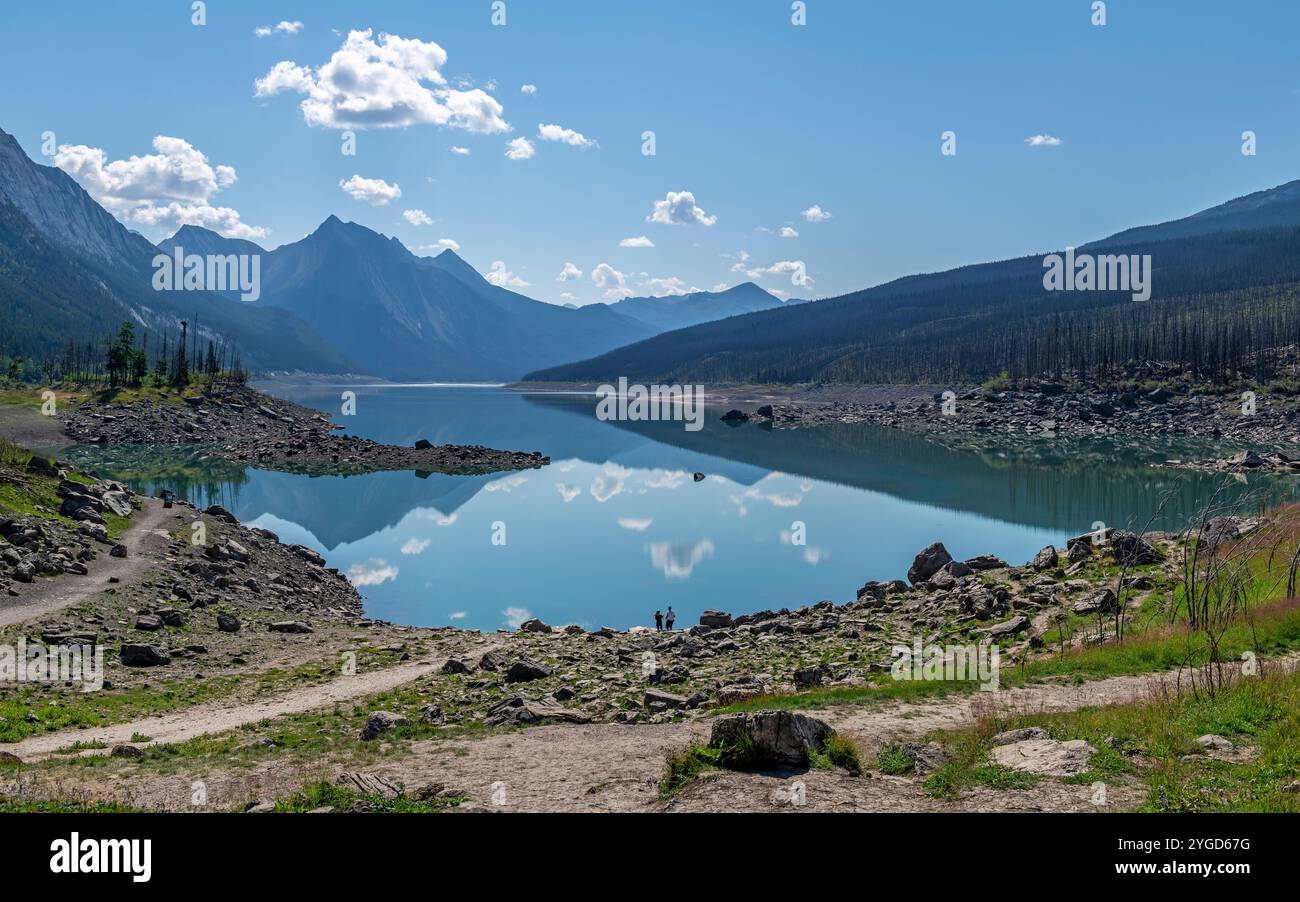 Riflessione sul lago di medicina con sagoma delle persone, parco nazionale di Jasper, Canada. Foto Stock