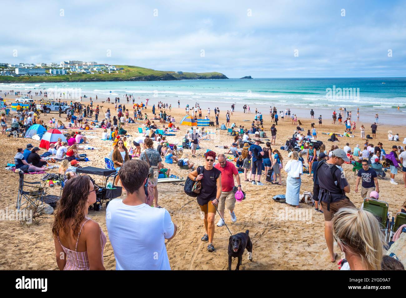 Turisti che si godono il sole estivo sull'iconica spiaggia Fistral di Newquay, in Cornovaglia, nel Regno Unito. Foto Stock
