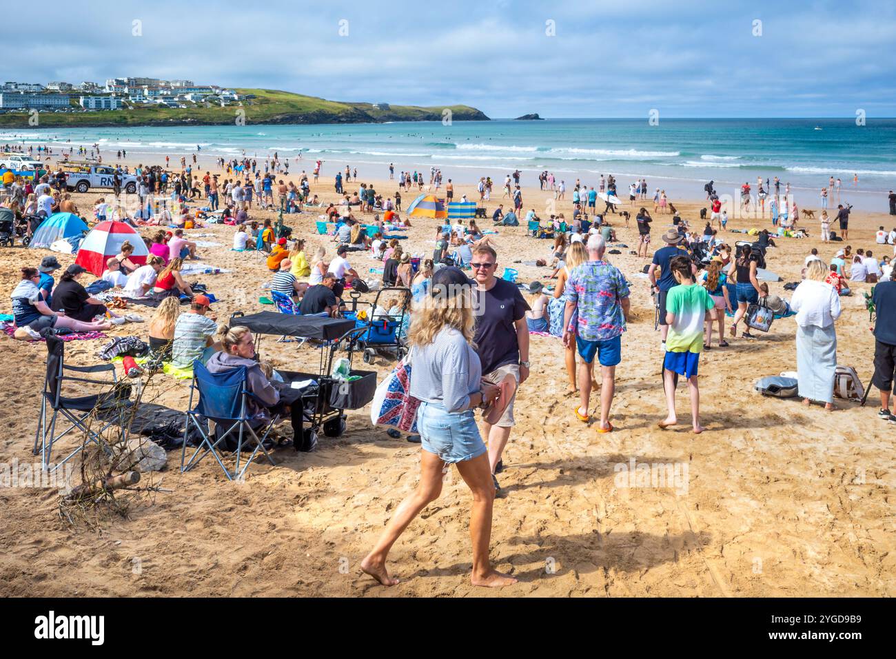 Turisti che si godono il sole estivo sull'iconica spiaggia Fistral di Newquay, in Cornovaglia, nel Regno Unito. Foto Stock