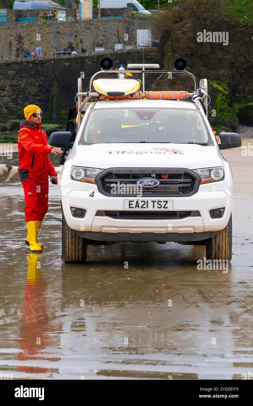 Un bagnino RNLI e il suo veicolo di risposta alle emergenze parcheggiavano a Towan Beach a Newquay in Cornovaglia nel Regno Unito. Foto Stock