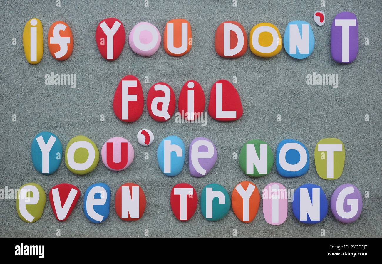 Se non fallisci, non stai nemmeno provando una citazione motivazionale composta da lettere di pietra colorate dipinte a mano su sabbia verde Foto Stock