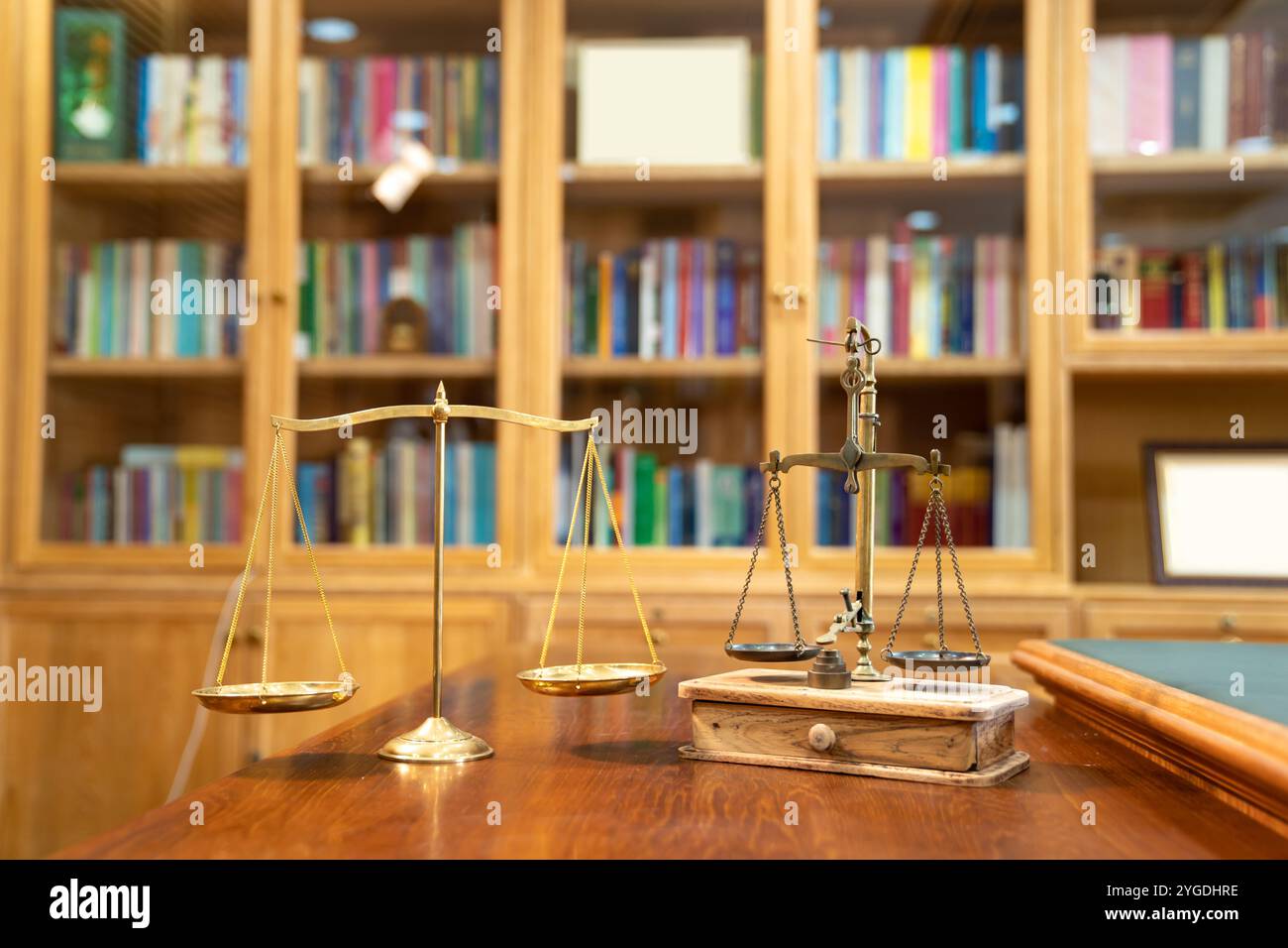 Il confronto tra Gold Vintage e la scala moderna si trova su un tavolo in legno di fronte allo scaffale della libreria. Foto Stock