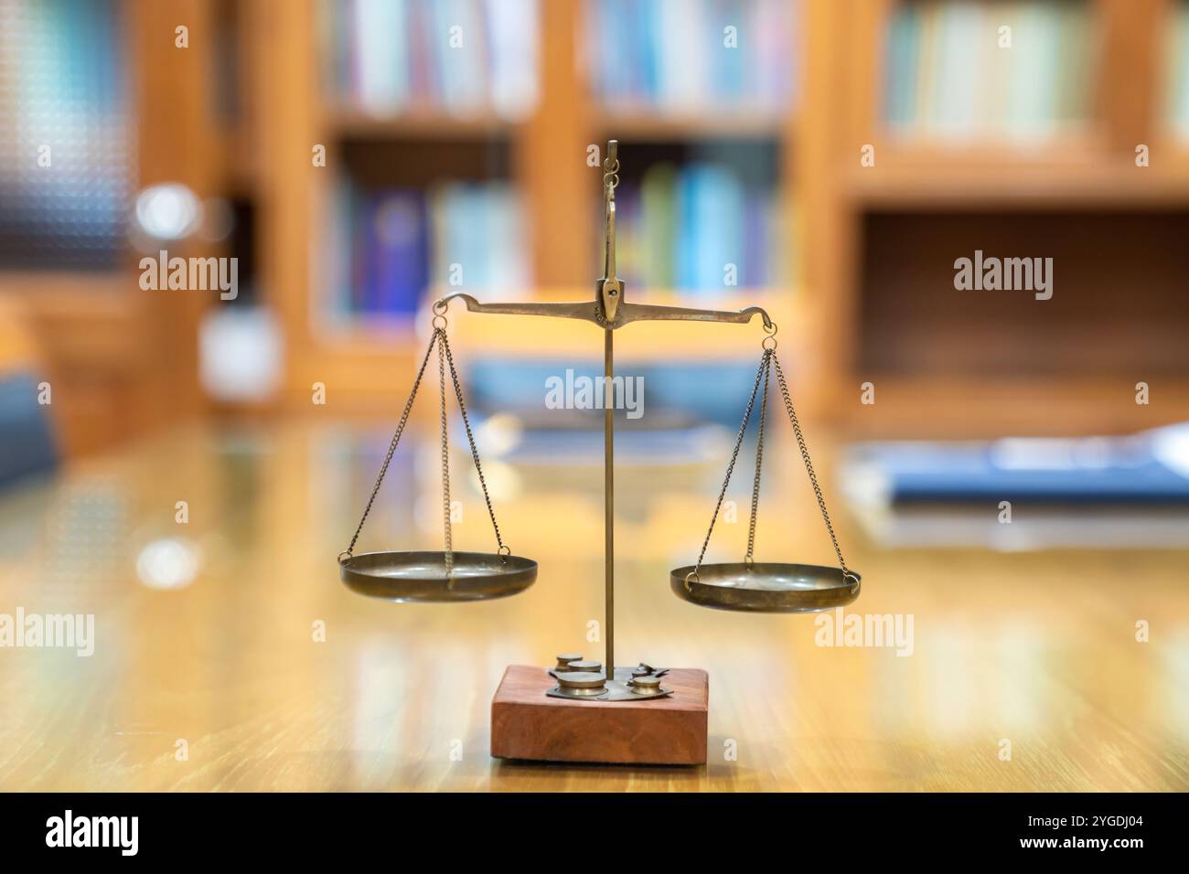 La vecchia scala di legge di Ottone è in stile vintage su un tavolo di vetro di legno nella sala riunioni dell'ufficio di Lawyer. Foto Stock