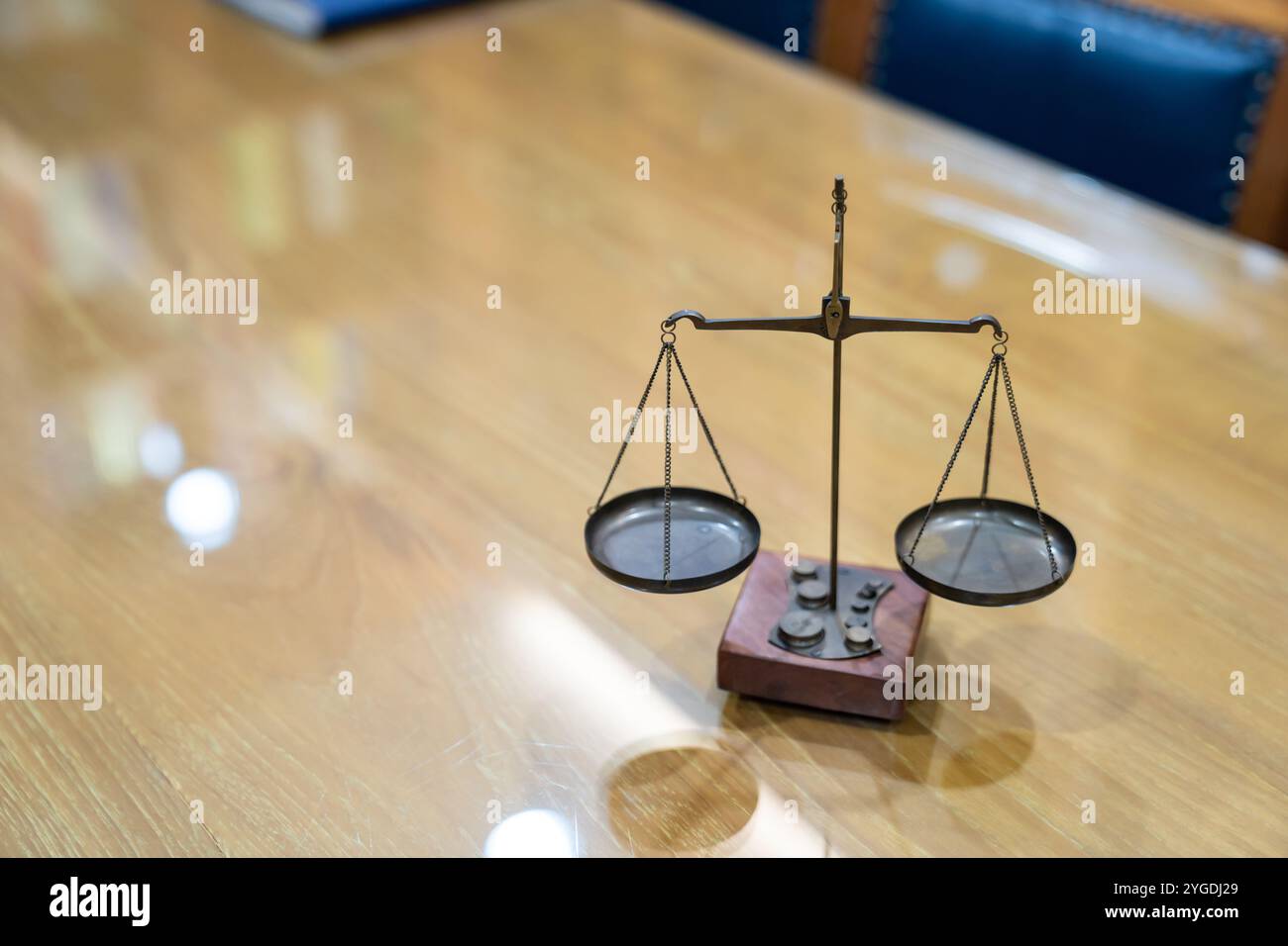 La vecchia scala di legge di Ottone è in stile vintage su un tavolo di vetro di legno nella sala riunioni dell'ufficio di Lawyer. Foto Stock
