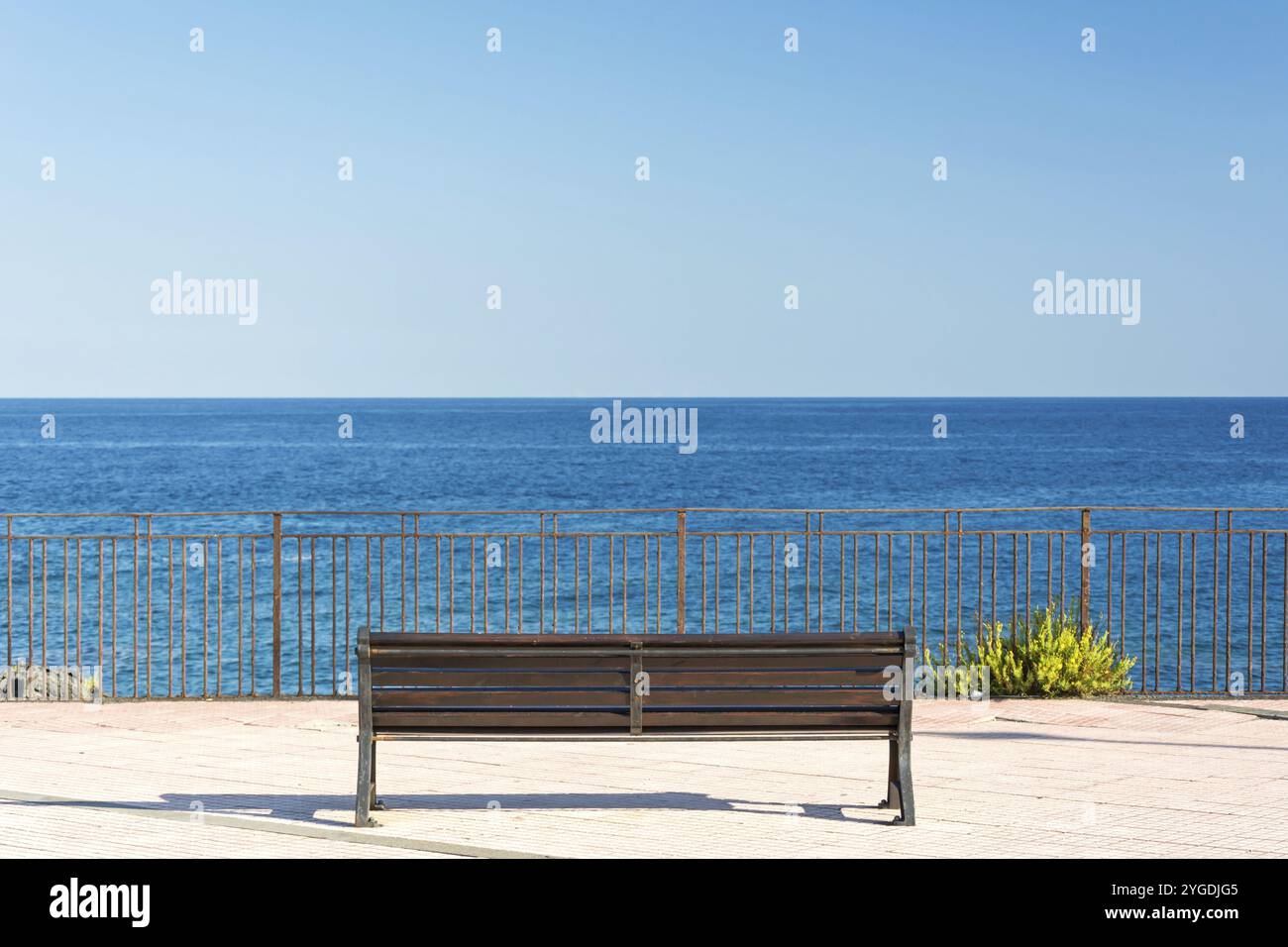 Panchina solitaria di fronte a un bellissimo panorama sull'oceano in Sicilia, Italia, Europa Foto Stock