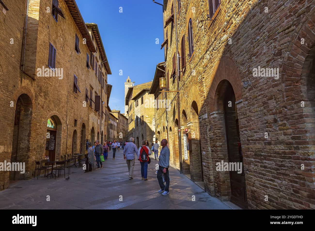 San Gimignano, Toscana, Italia, 25 ottobre 2018: Antica strada medievale e torre nella tipica cittadina toscana, popolare destinazione turistica, Europa Foto Stock