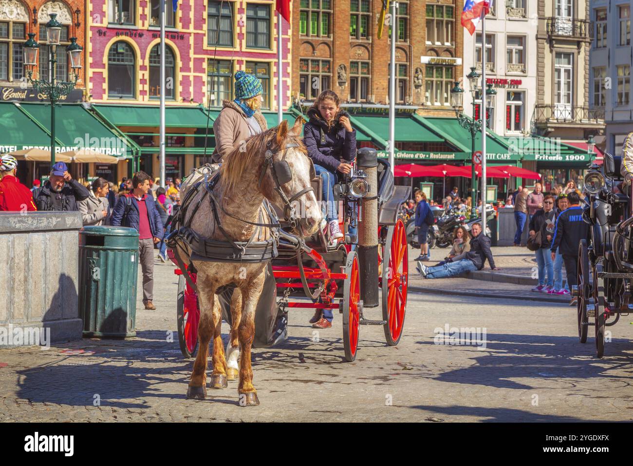 Bruges, Belgio, 10 aprile 2016: Carrozza trainata da cavalli sulla piazza del mercato nella popolare destinazione belga Bruges, Europa Foto Stock