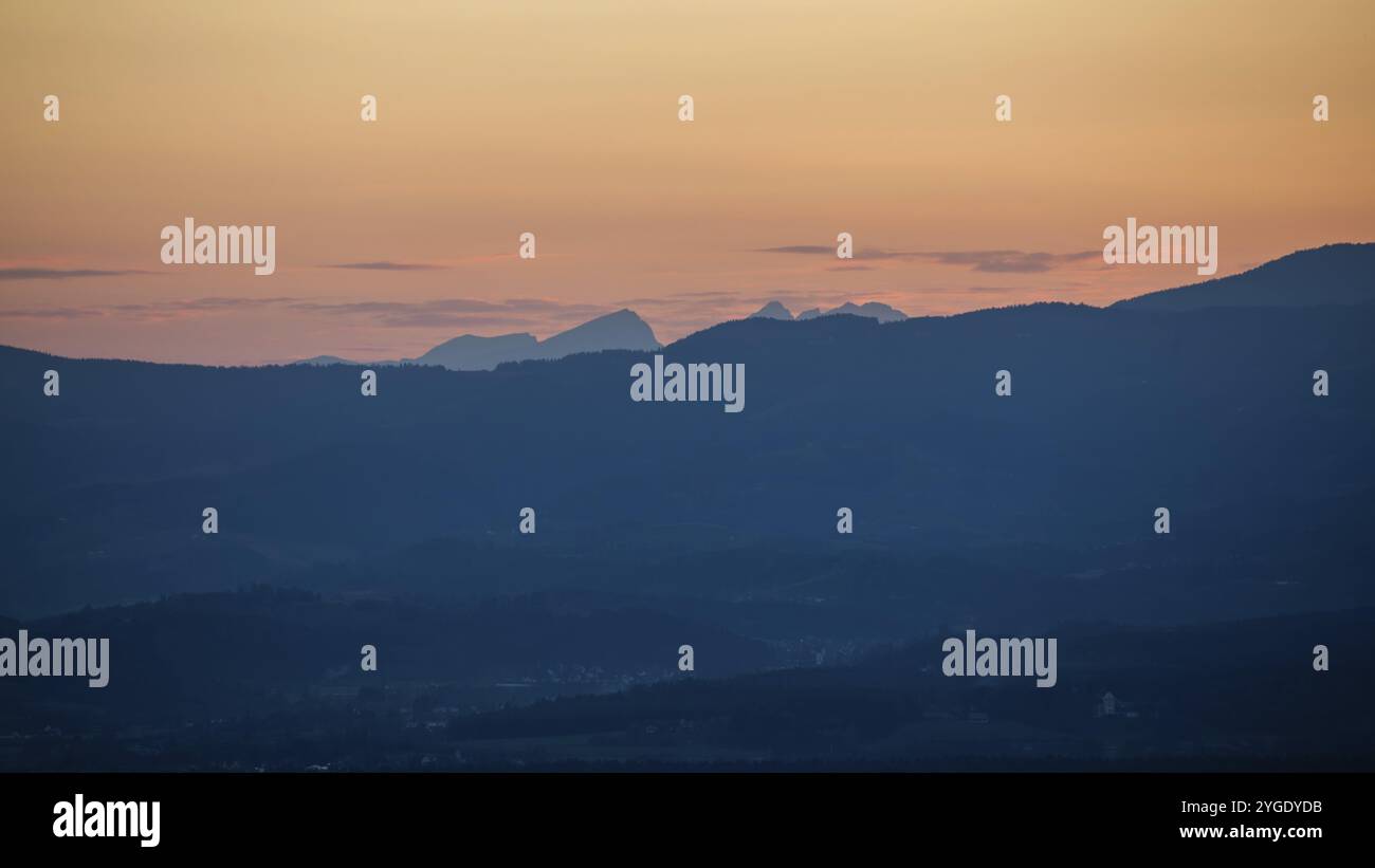 Montagne e colline al tramonto, atmosfera nuvolosa dopo il tramonto sulla strada del vino Sausal, St. Andrae-Hoech, regione vinicola di Sausal, Stiria Foto Stock