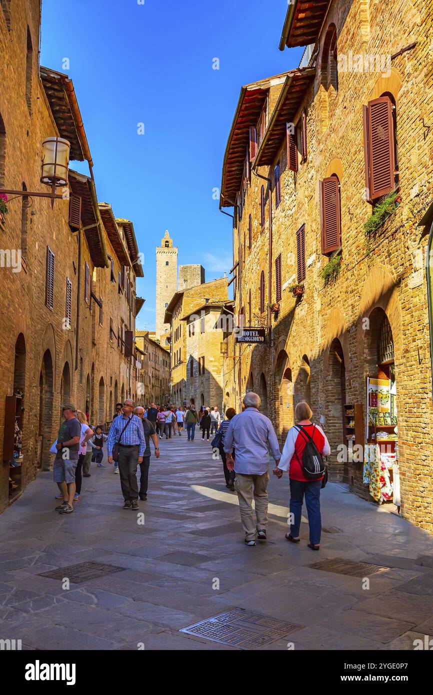 San Gimignano, Toscana, Italia, 25 ottobre 2018: Antica strada medievale e torre nella tipica cittadina toscana, popolare destinazione turistica, Europa Foto Stock