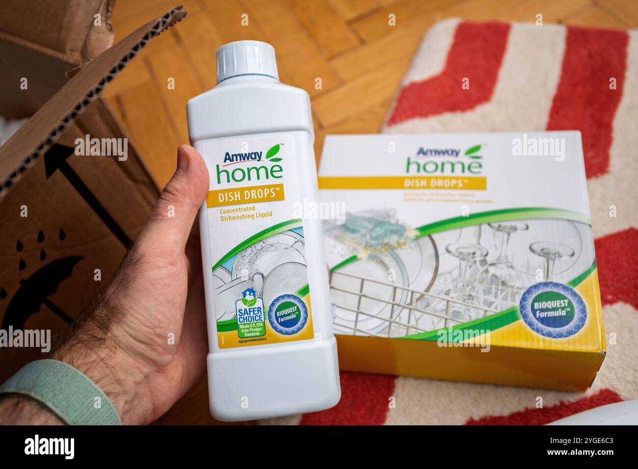 Francoforte, Germania - 26 marzo 2020: Una bottiglia di Amway Home Dish Drops liquido concentrato per piatti tenuto accanto alla sua scatola - offre scelta più sicura e BioQuest Formula per una pulizia ecocompatibile Foto Stock