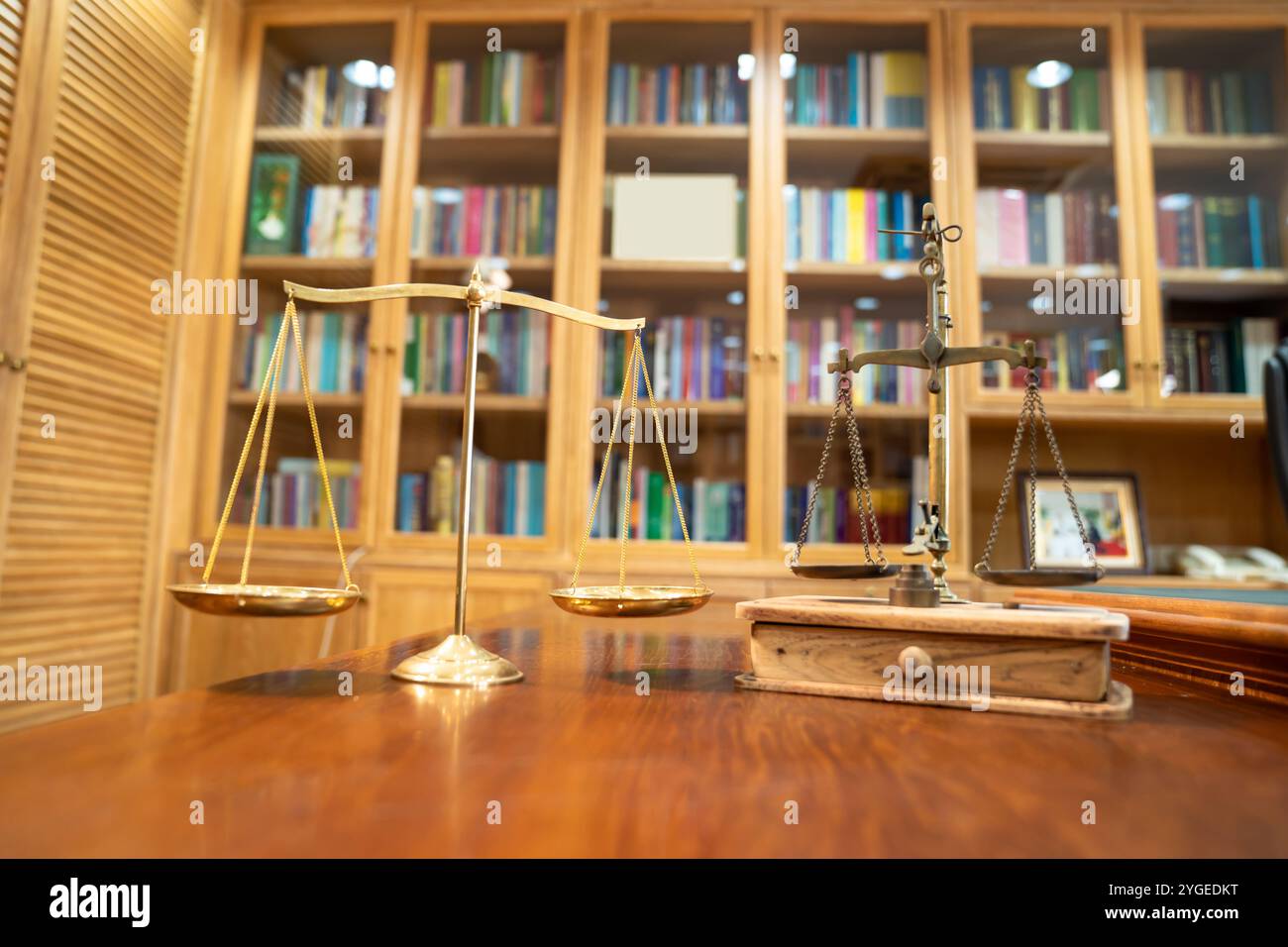 Il confronto tra Gold Vintage e la scala moderna si trova su un tavolo in legno di fronte allo scaffale della libreria. Foto Stock