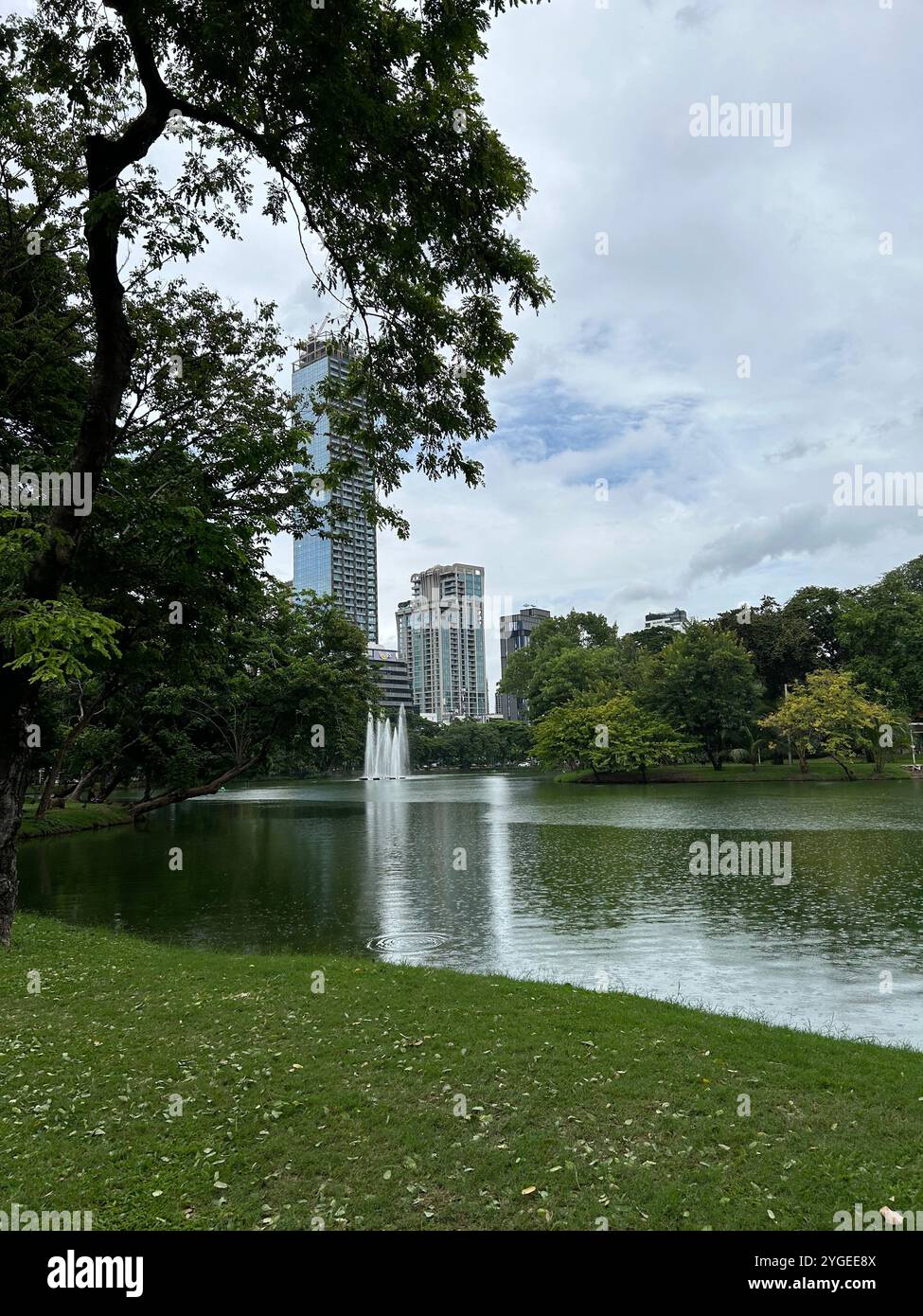 Parco urbano con fontana e paesaggio urbano sullo sfondo Foto Stock