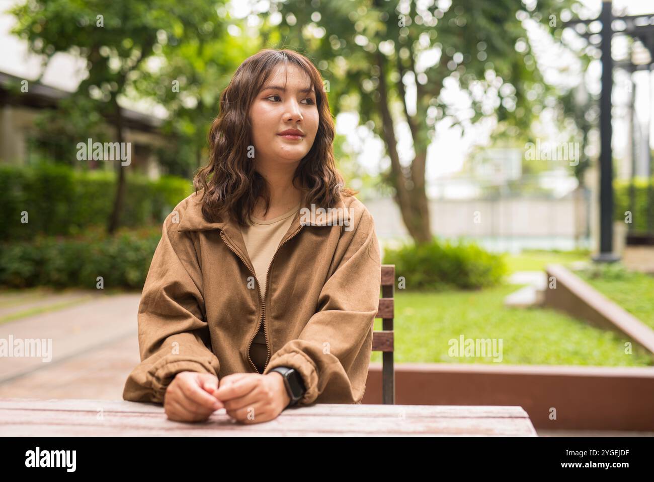 Ritratto di una bella e giovane donna asiatica thailandese seduta all'aperto Foto Stock