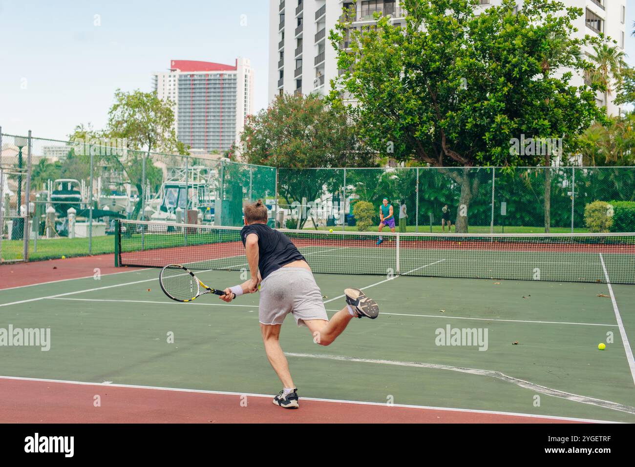 uomo che gioca a tennis all'aperto. Il giovane tiene una racchetta da tennis sulla spalla. Foto di alta qualità Foto Stock